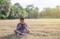 Happy cute Asian boy play game with smartphone sit on the park Royalty Free Stock Photo