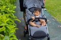 Happy and cute Asian Chinese baby boy sitting on stroller at park during evening Royalty Free Stock Photo