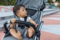 Happy and cute Asian Chinese baby boy sitting on stroller at park during evening Royalty Free Stock Photo