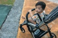 Happy and cute Asian Chinese baby boy sitting on stroller at park during evening Royalty Free Stock Photo