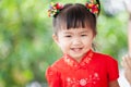 Happy cute asian child girl in chinese tradition dress smiling and wishing you a happy in Chinese New Year Royalty Free Stock Photo