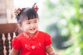 Happy cute asian child girl in chinese tradition dress smiling and wishing you a happy in Chinese New Year Royalty Free Stock Photo