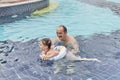 Happy cute Asian little girl and her grandfather spend time together in open air thermal pool. Royalty Free Stock Photo
