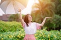 Happy cute asian teen with umbrella pretect from rain in raining season or uv sun light in summer