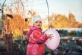 Happy cute baby girl playing with balloon outdoors on backyard in countryside Royalty Free Stock Photo