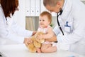 Happy cute baby at health exam at doctor`s office. Medicine and health care concept Royalty Free Stock Photo