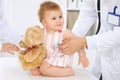 Happy cute baby at health exam at doctor`s office. Medicine and health care concept Royalty Free Stock Photo