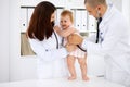 Happy cute baby at health exam at doctor`s office. Medicine and health care concept Royalty Free Stock Photo