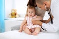 Happy cute baby at health exam at doctor`s office. Medicine and health care concept Royalty Free Stock Photo