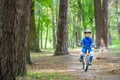 Happy cute blond kid boy having fun his first bike on sunny summer day, outdoors. child making sports. Active leisure for childre Royalty Free Stock Photo