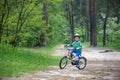 Happy cute blond kid boy having fun his first bike on sunny summer day, outdoors. child making sports. Active leisure for childre Royalty Free Stock Photo