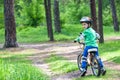 Happy cute blond kid boy having fun his first bike on sunny summer day, outdoors. child making sports. Active leisure for childre Royalty Free Stock Photo