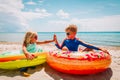 Happy cute boy and girl play with floaties on beach Royalty Free Stock Photo