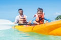 Happy boy and his father kayaking at tropical sea on yellow kayak