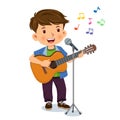 Happy cute boy is playing the guitar and singing into a microphone Royalty Free Stock Photo