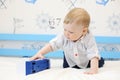 Happy cute boy toddler plays with toy train on bed