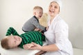 Happy cute boys playing with stethoscope in doctors office, hugging plush toy bear and smiling at camera. Female pediatrics. Copy Royalty Free Stock Photo