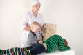 Happy cute boys playing with stethoscope in doctors office, hugging plush toy bear and smiling at camera. Female pediatrics. Royalty Free Stock Photo