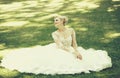 Happy cute bride in white wedding dress on green grass Royalty Free Stock Photo