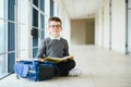 Happy cute clever boy in glasses with school bag and book in his hand. First time to school. Back to school Royalty Free Stock Photo