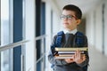 Happy cute clever boy in glasses with school bag and book in his hand. First time to school. Back to school. Royalty Free Stock Photo