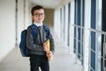 Happy cute clever boy in glasses with school bag and book in his hand. First time to school. Back to school. Royalty Free Stock Photo