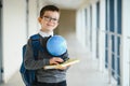 Happy cute clever boy in glasses with school bag and book in his hand. First time to school. Back to school. Royalty Free Stock Photo