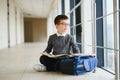 Happy cute clever boy in glasses with school bag and book in his hand. First time to school. Back to school. Royalty Free Stock Photo