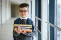 Happy cute clever boy in glasses with school bag and book in his hand. First time to school. Back to school. Royalty Free Stock Photo