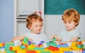 Happy cute clever boy pupils. Toddler children friends play with blocks, trains and cars. Educational toys for preschool Royalty Free Stock Photo