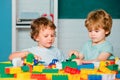 Happy cute clever boy pupils. Toddler children friends play with blocks, trains and cars. Educational toys for preschool Royalty Free Stock Photo