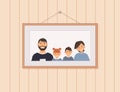 Happy cute family portrait of parents and kids is hanging on nail on wall: father, mother, son and daughter. Family of four