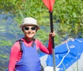 Happy cute girl holding paddle near a kayak Royalty Free Stock Photo