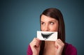 Happy cute girl holding paper with funny smiley drawing Royalty Free Stock Photo