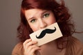 Happy cute girl holding paper with mustache drawing Royalty Free Stock Photo