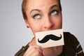 Happy cute girl holding paper with mustache drawing Royalty Free Stock Photo