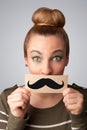 Happy cute girl holding paper with mustache drawing Royalty Free Stock Photo