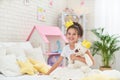 Happy cute girl sitting on the bed in her children`s room and hugs Teddy bear Royalty Free Stock Photo