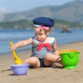 Happy cute girl in swimsuit playing with sand on beach Royalty Free Stock Photo