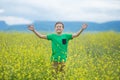 Happy cute handsome little kid boy on green grass lawn with blooming yellow dandelion flowers on sunny spring or summer day. Littl Royalty Free Stock Photo