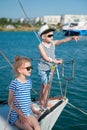 Happy cute kids aboard luxury yacht in summer sunny day in port Royalty Free Stock Photo