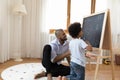 Happy little african american boy drawing with father. Royalty Free Stock Photo