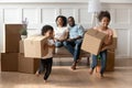 Happy little african kids holding boxes play on moving day Royalty Free Stock Photo