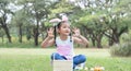 Happy cute little Asian child girl hunting Easter eggs, wearing bunny ears. kid counting eggs in basket after play hunt eggs game Royalty Free Stock Photo