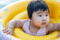Happy cute little baby child learning to swim with swimming ring in an indoor pool. Smiling little child, newborn girl having fun Royalty Free Stock Photo
