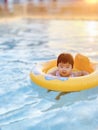 Happy cute little baby child learning to swim with swimming ring in an indoor pool. Smiling little child, newborn girl having fun Royalty Free Stock Photo