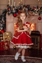 Happy cute little blonde girl with long hair in a red dress, waiting for Christmas and New year on the background of Royalty Free Stock Photo