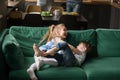 Kids sister and brother laughing tickling on sofa playing togeth