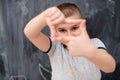 Happy boy making hand frame gesture in front of chalkboard Royalty Free Stock Photo