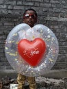 A happy cute little boy holding a heart shape balloon Royalty Free Stock Photo